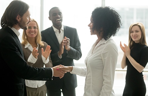Woman being congratulated by colleagues