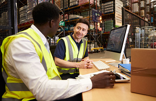 Staff discuss warehouse logistics in an on-site office